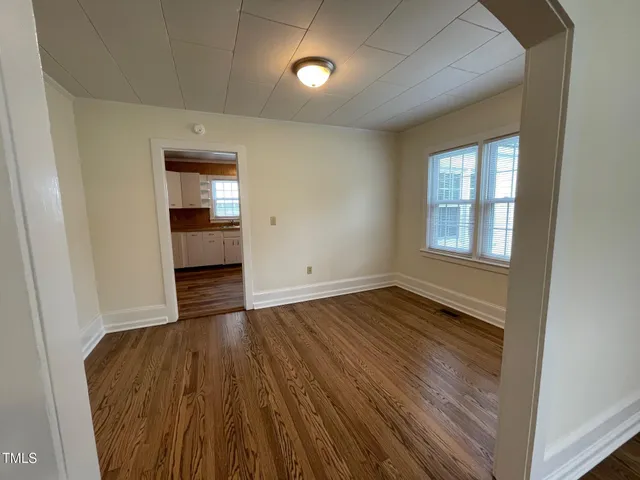 a view of empty room with wooden floor