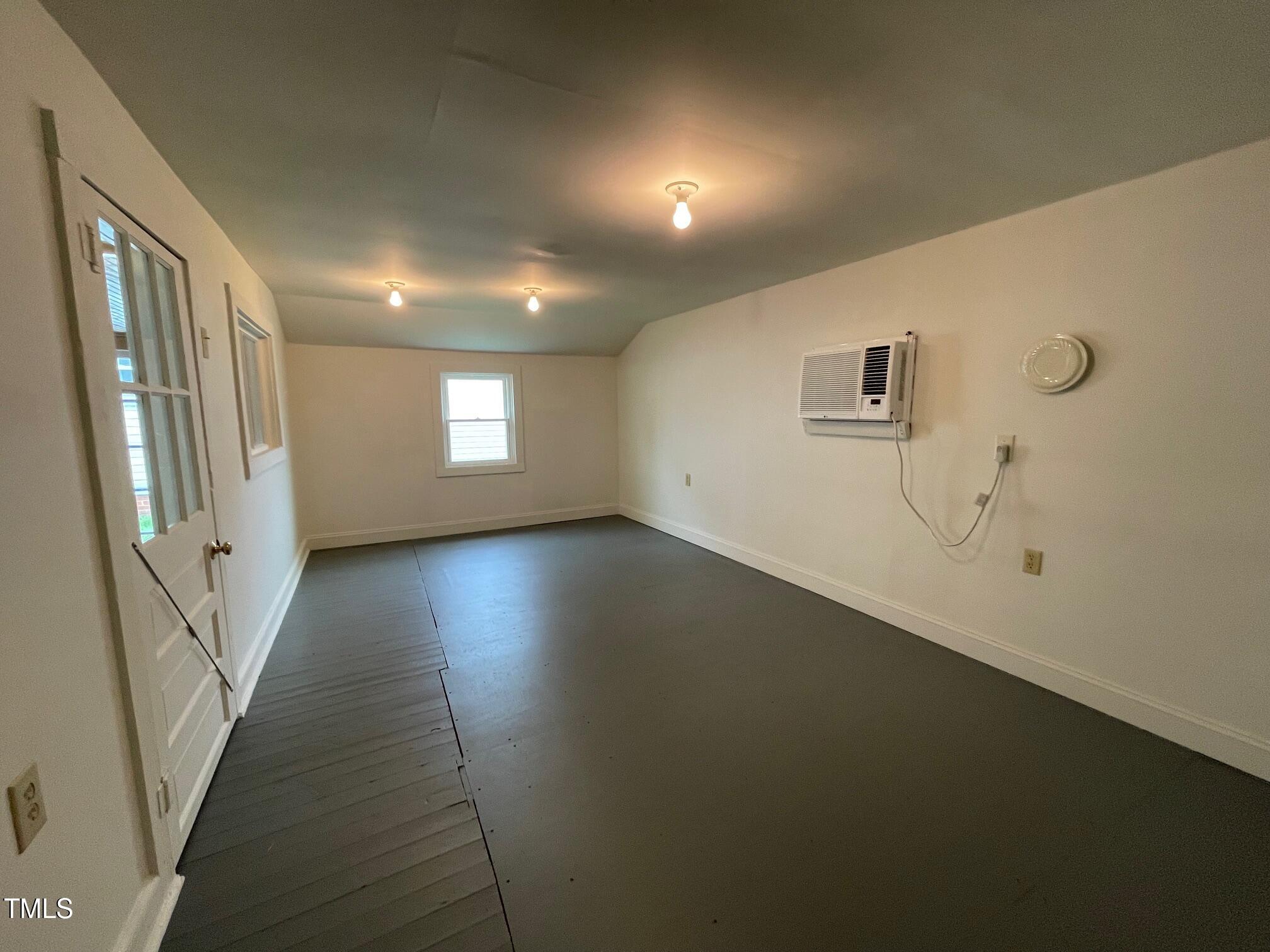 140 South Dunn Street Angier, NC 27501 - Photo 25 of 27 an empty room with wooden floor and windows