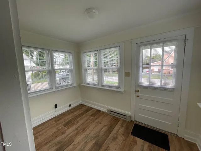 a room with wooden floor and windows