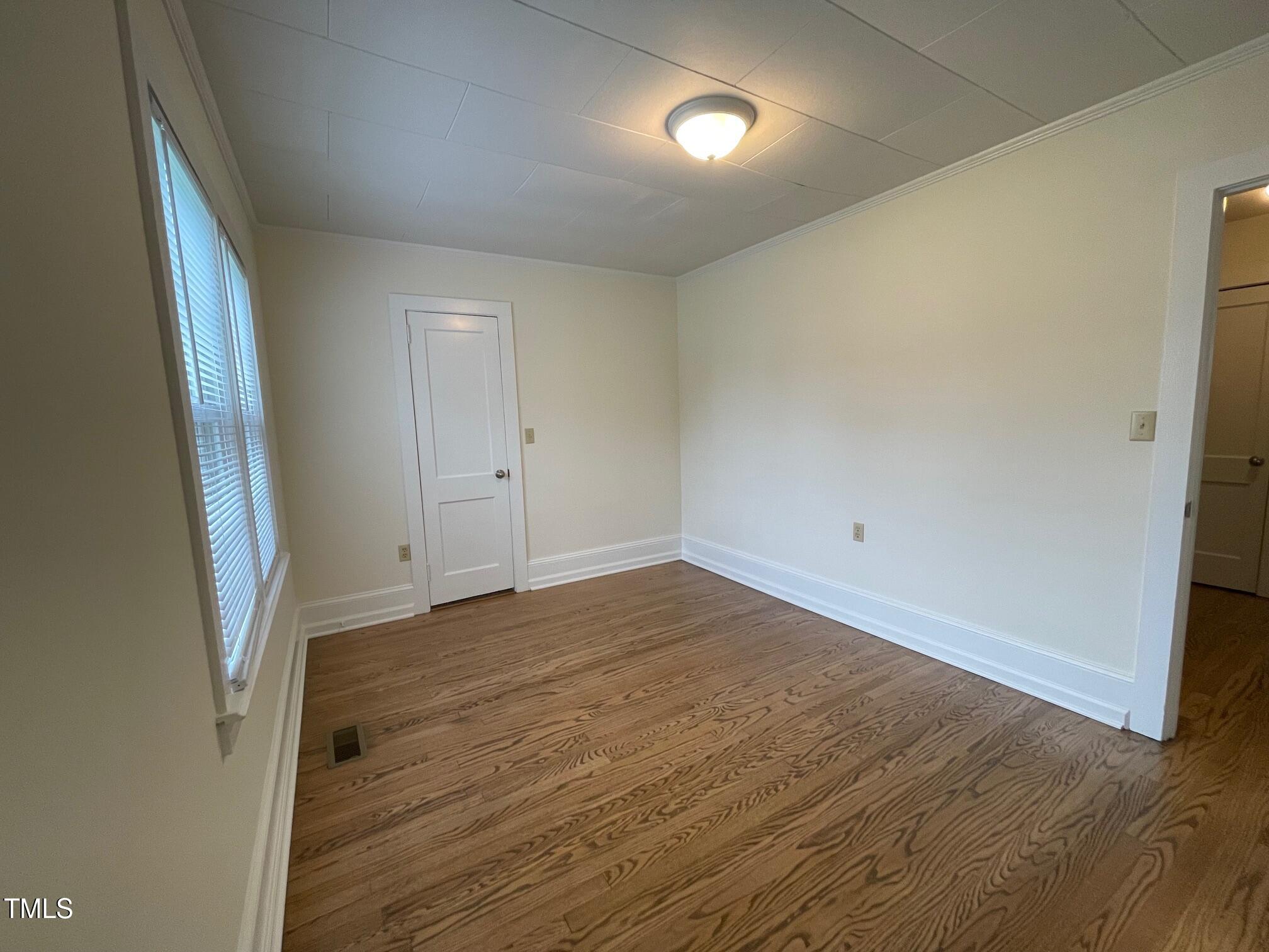 140 South Dunn Street Angier, NC 27501 - Photo 10 of 27 an empty room with wooden floor and entrance