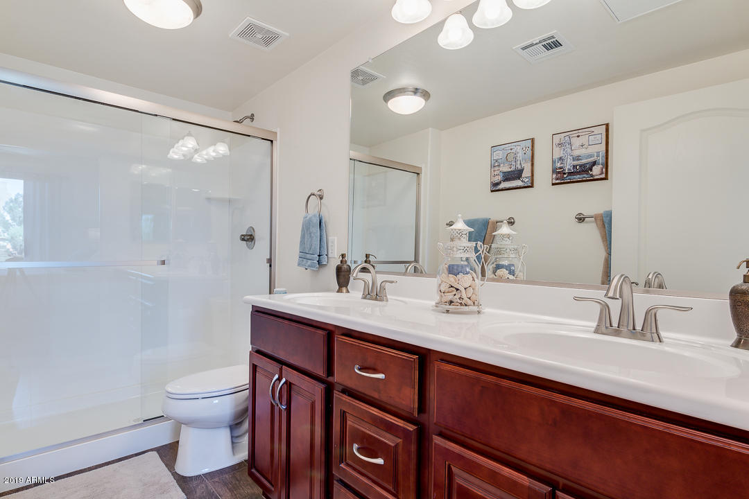 7726 East Baseline Road, Unit 143 Mesa, AZ 85209 - Photo 15 of 27 a bathroom with a toilet a sink and mirror