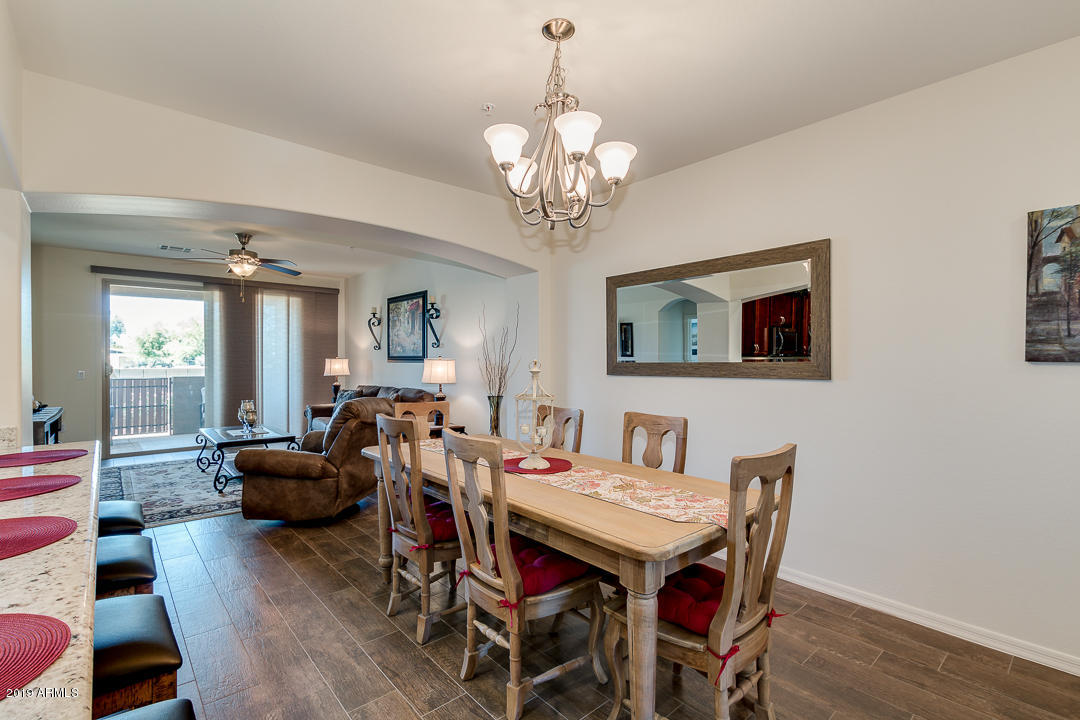 7726 East Baseline Road, Unit 143 Mesa, AZ 85209 - Photo 4 of 27 a view of a dining room with furniture wooden floor and chandelier