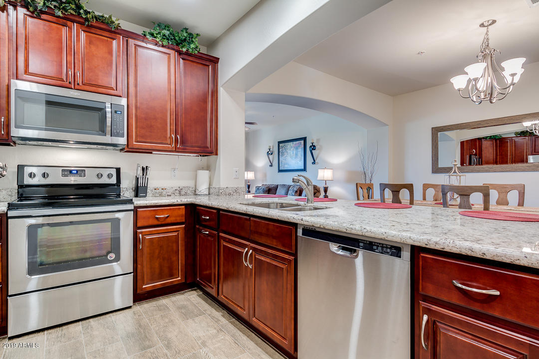 7726 East Baseline Road, Unit 143 Mesa, AZ 85209 - Photo 7 of 27 a kitchen with stainless steel appliances granite countertop a stove microwave and sink