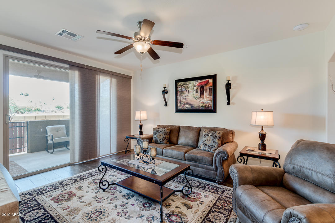 7726 East Baseline Road, Unit 143 Mesa, AZ 85209 - Photo 10 of 27 a living room with furniture a rug and a chandelier