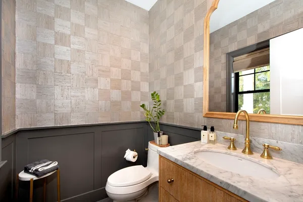 a bathroom with a granite countertop sink a toilet and mirror