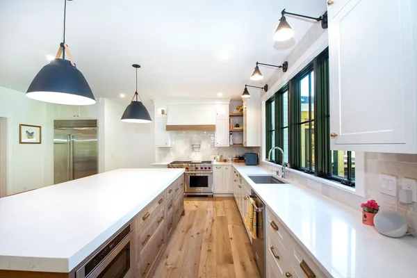 a kitchen with kitchen island granite countertop a sink and a stove