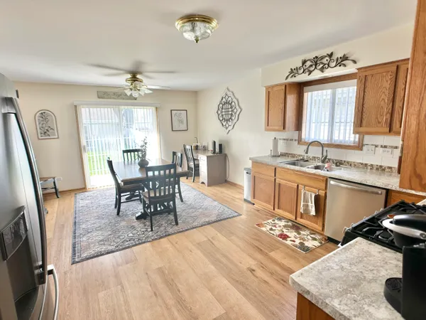 a living room with stainless steel appliances granite countertop furniture a fireplace a rug and a window
