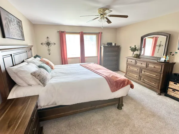 a bedroom with a bed and dresser with mirror