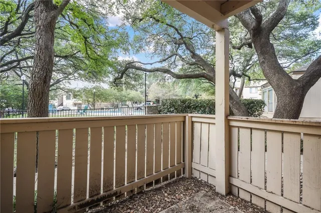 a view of a wooden fence under a large tree