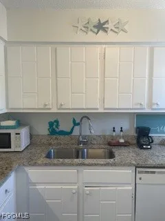 a kitchen with white cabinets and a sink
