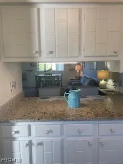 a kitchen with granite countertop white cabinets and a counter top space