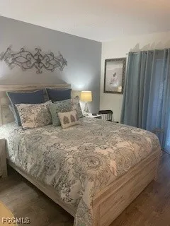 a bedroom with a bed and a painting on the wall