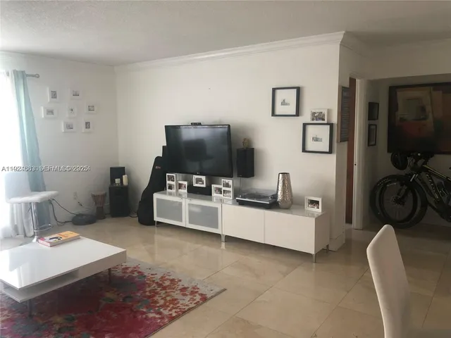 a living room with furniture a flat screen tv and a large window