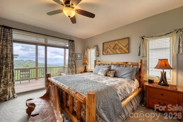 a bedroom with a bed a flat screen tv and a large window with the garden view