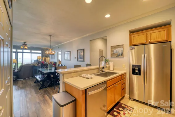 a kitchen with granite countertop kitchen island stainless steel appliances a stove a sink a refrigerator cabinets and dining table