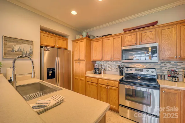 a kitchen with granite countertop kitchen island stainless steel appliances a stove a sink a refrigerator cabinets and dining table