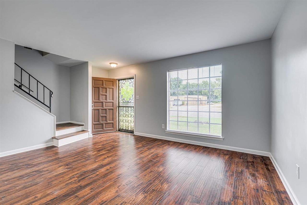 5565 Pleasant View Road, Unit 5565 Memphis, TN 38134 - Photo 2 of 25 a view of an empty room with wooden floor and a window