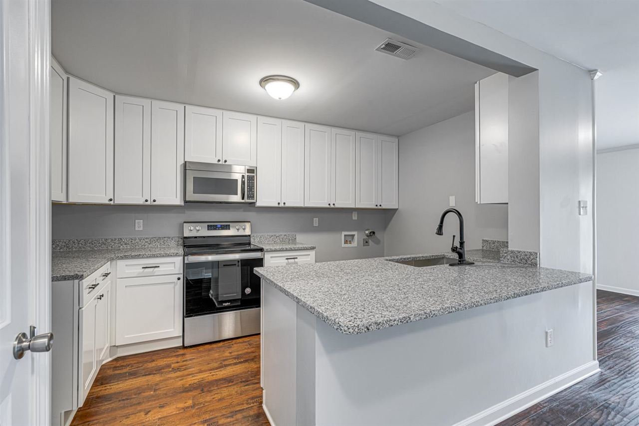 5565 Pleasant View Road, Unit 5565 Memphis, TN 38134 - Photo 4 of 25 a kitchen with stainless steel appliances granite countertop a stove a sink and white cabinets