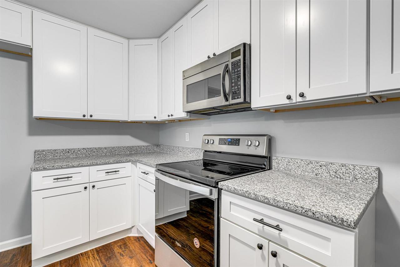5565 Pleasant View Road, Unit 5565 Memphis, TN 38134 - Photo 6 of 25 a kitchen with granite countertop white cabinets and a stove a oven with white countertops
