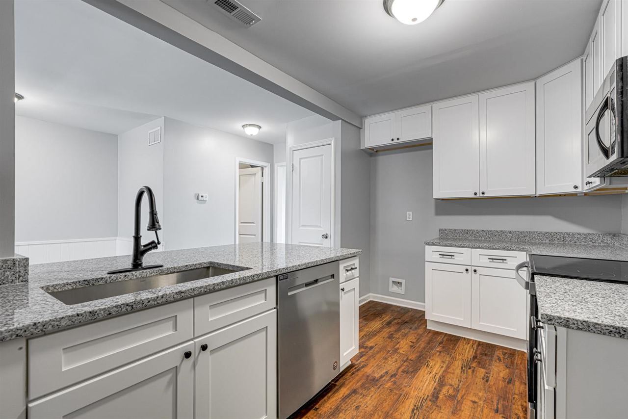 5565 Pleasant View Road, Unit 5565 Memphis, TN 38134 - Photo 7 of 25 a kitchen with granite countertop white cabinets and white appliances