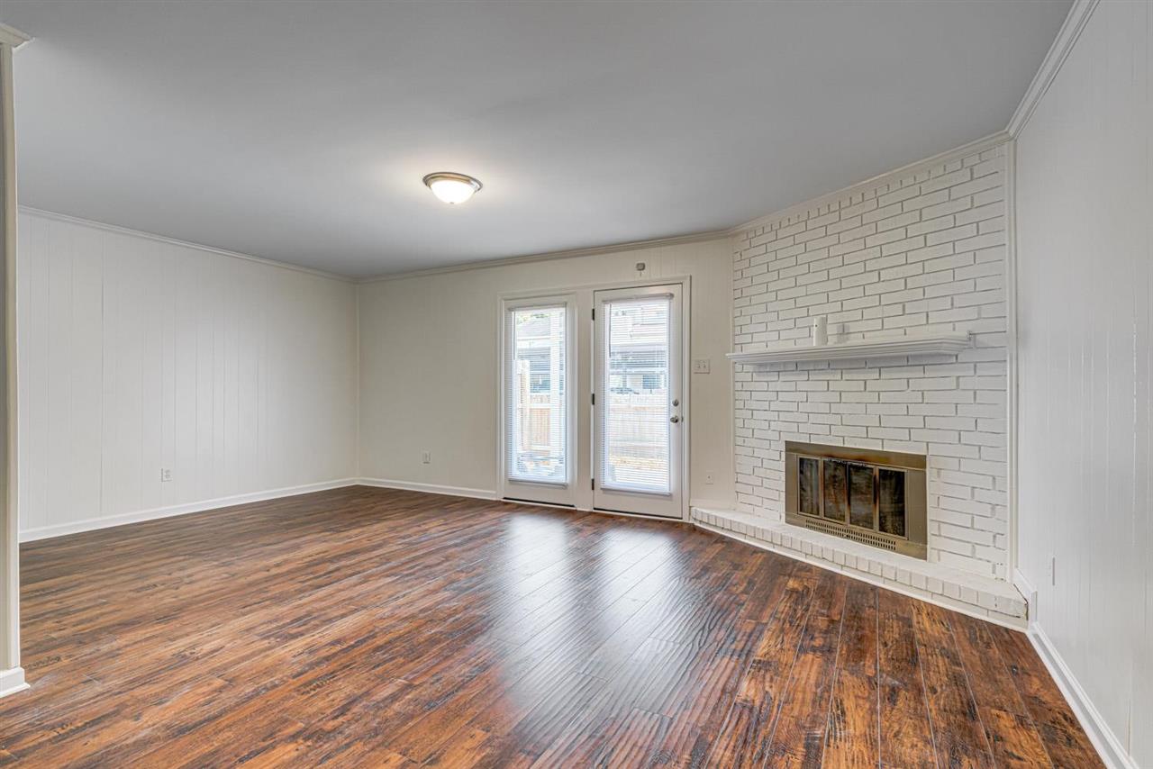 5565 Pleasant View Road, Unit 5565 Memphis, TN 38134 - Photo 8 of 25 an empty room with wooden floor fireplace and windows