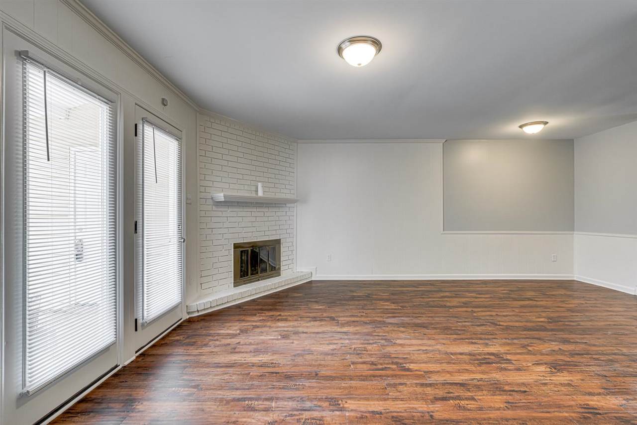 5565 Pleasant View Road, Unit 5565 Memphis, TN 38134 - Photo 10 of 25 an empty room with wooden floor fireplace and windows