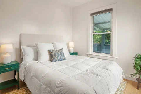 a large bed sitting in a bedroom next to a window