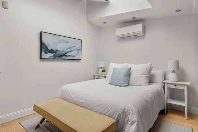 a bedroom with a bed and a lamp on dresser