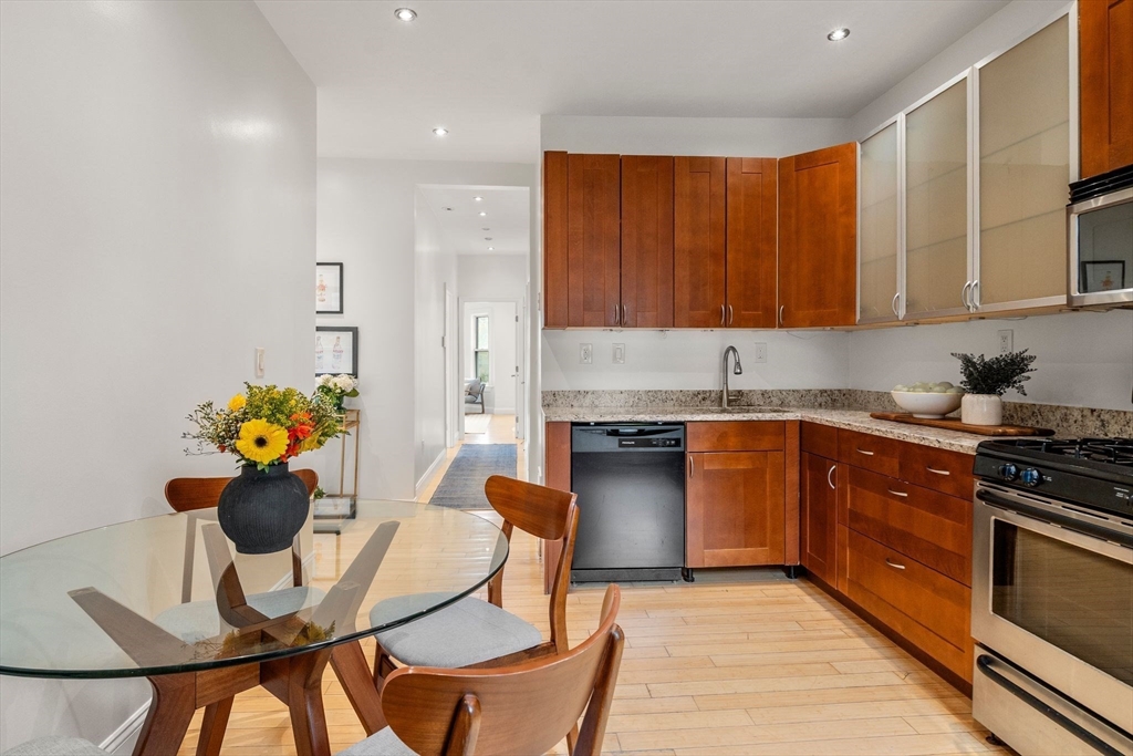 178 Hyde Park Avenue, Unit 3 Boston, MA 02130 - Photo 8 of 23 a kitchen with stainless steel appliances granite countertop a stove a sink a dining table and chairs