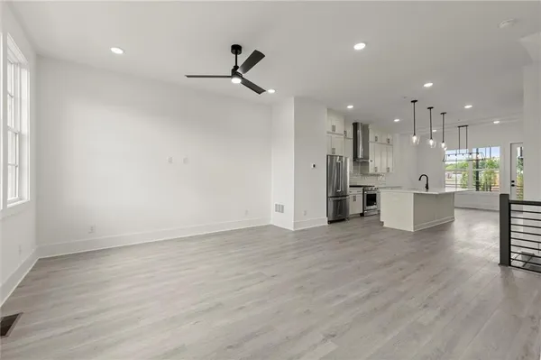 a view of a big room with wooden floor windows and a kitchen