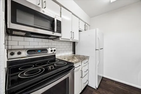 a kitchen with granite countertop a stove and a refrigerator