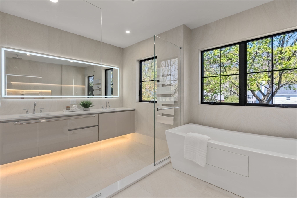 470 Quinobequin Road Newton, MA 02468 - Photo 20 of 37 a spacious bathroom with a granite countertop tub and a sink