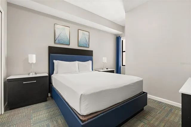 a bed sitting in a bedroom and night stand