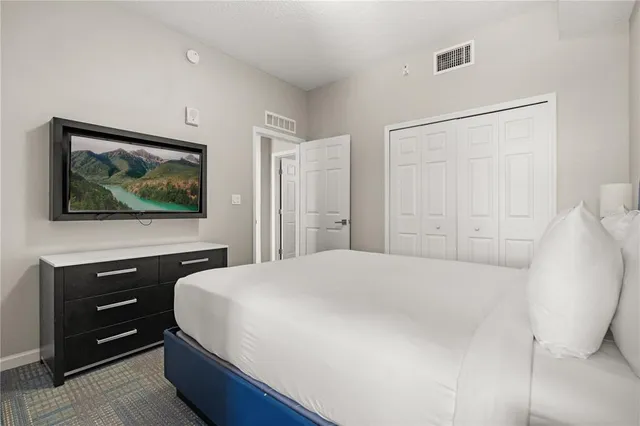 a bedroom with a bed and a flat screen tv