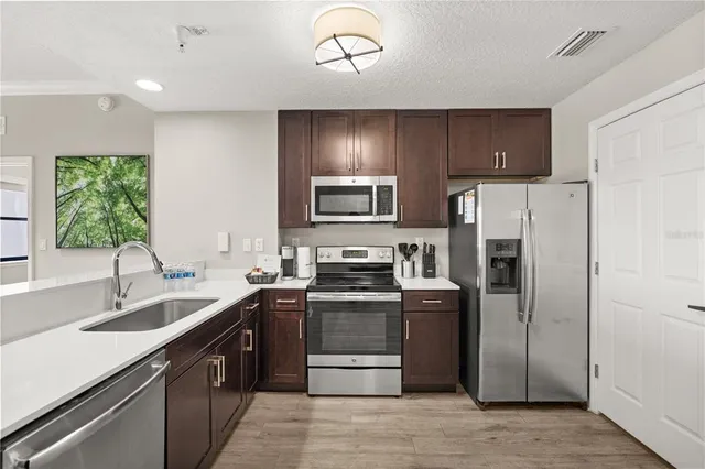 a kitchen with stainless steel appliances granite countertop a refrigerator and a sink