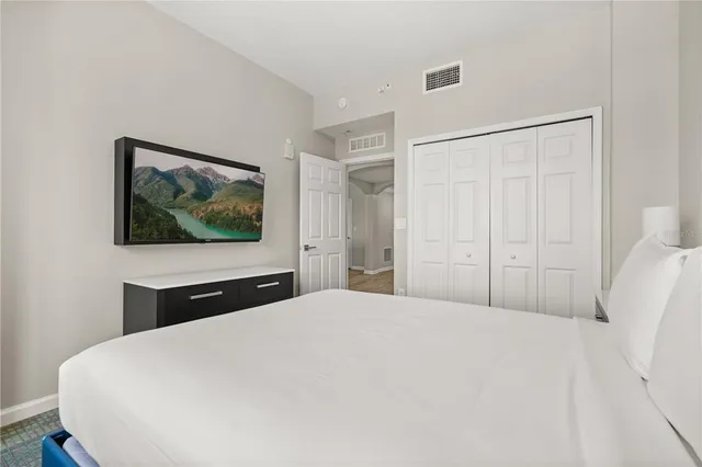 a large bed sitting in a bedroom and a chandelier