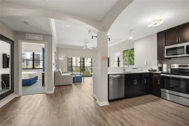 a large kitchen with wooden floors and stainless steel appliances