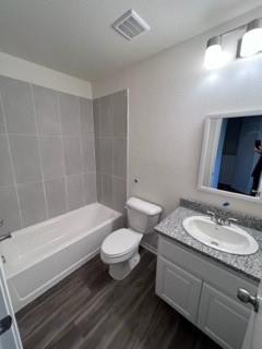 807 South 6th Street, Unit 3 Bonham, TX 75418 - Photo 4 of 8 Bathroom featuring vanity, dark wood-type flooring, and washtub / shower combination