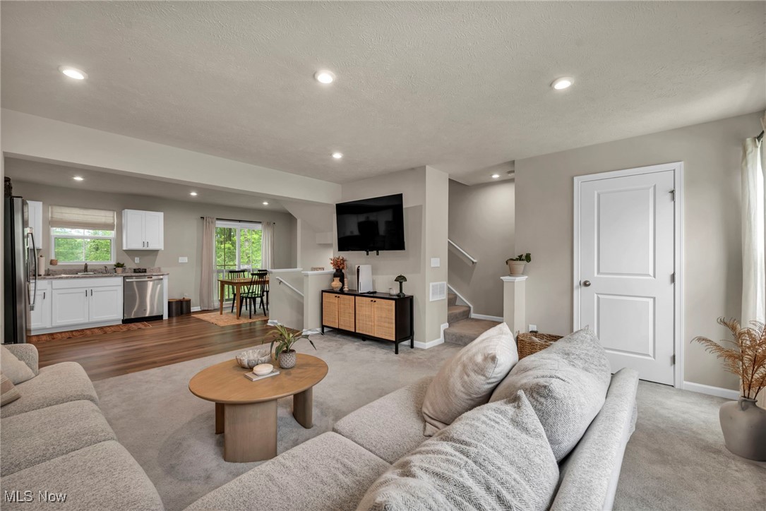 191 Raintree Lane Painesville, OH 44077 - Photo 7 of 35 Living room with recessed lighting, light carpet, and stairway