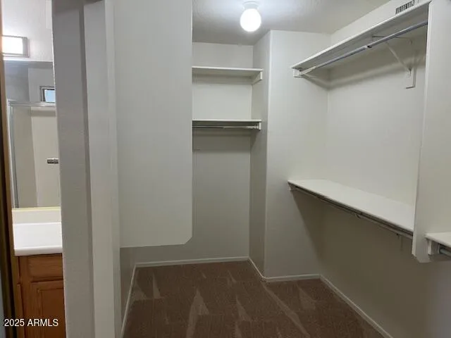 a view of staircase with railing and white walls