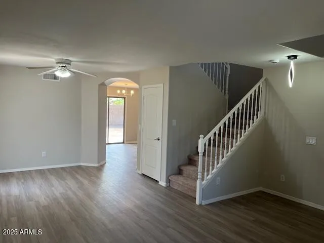a view of a room with wooden floor staircase and a hallway