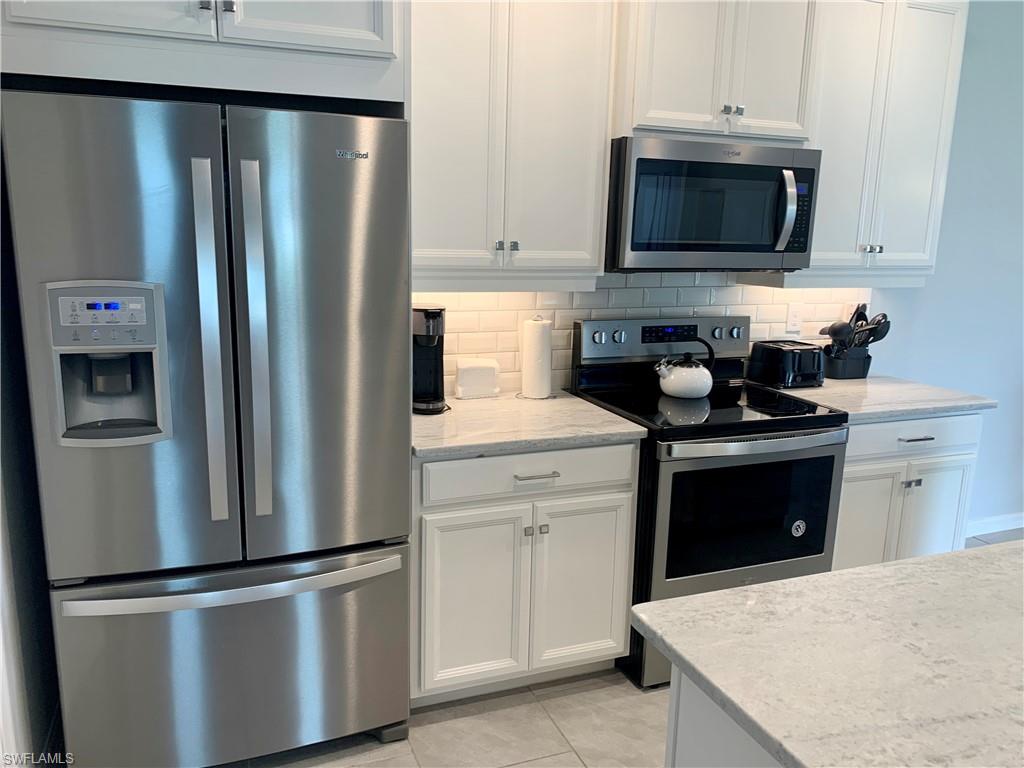 14632 Edgewater Circle Naples, FL 34114 - Photo 11 of 35 a kitchen with a refrigerator stove and microwave