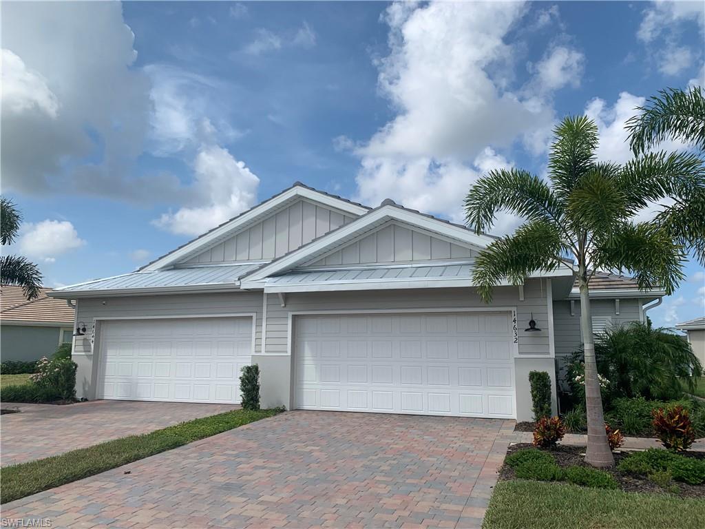 14632 Edgewater Circle Naples, FL 34114 - Photo 2 of 35 a front view of a house with a yard and garage