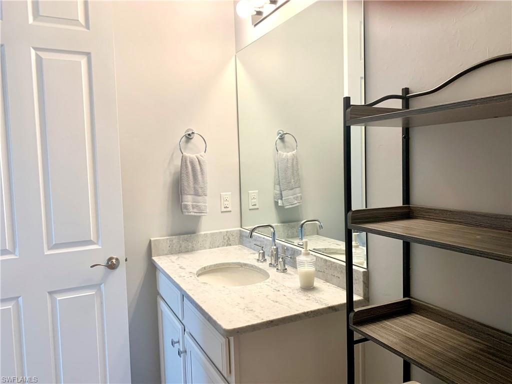 14632 Edgewater Circle Naples, FL 34114 - Photo 23 of 35 a bathroom with a sink and a mirror