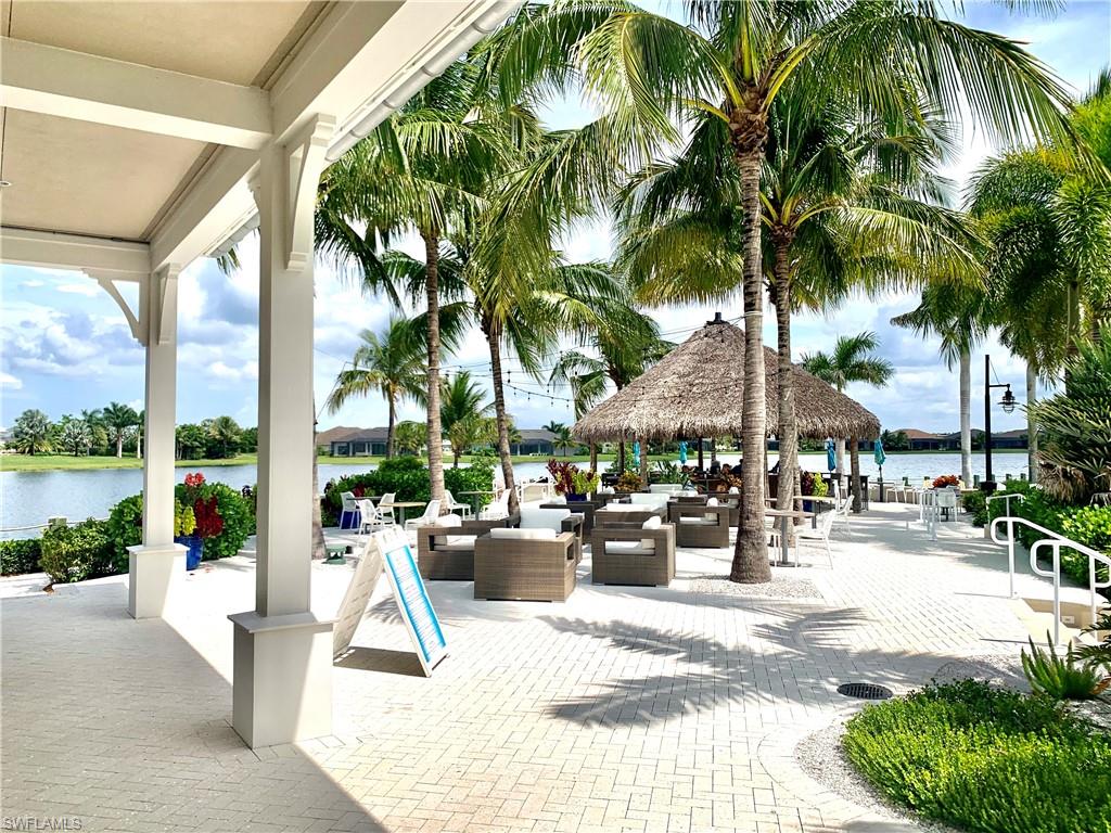 14632 Edgewater Circle Naples, FL 34114 - Photo 31 of 35 a view of a patio with a table and chairs potted plants and palm trees