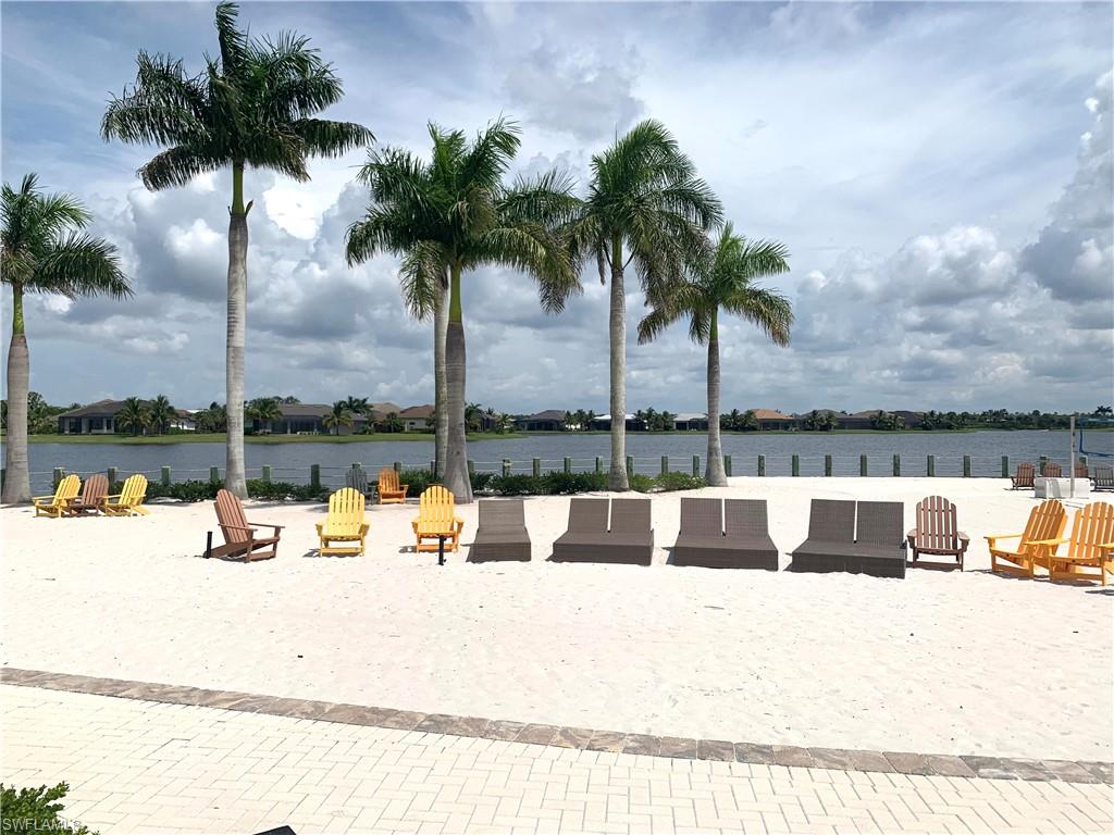 14632 Edgewater Circle Naples, FL 34114 - Photo 32 of 35 a view of swimming pool with a table and chair and palm tree