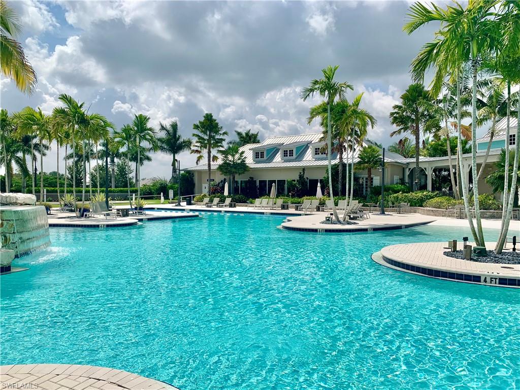 14632 Edgewater Circle Naples, FL 34114 - Photo 34 of 35 a view of a swimming pool with lawn chairs plants and palm trees
