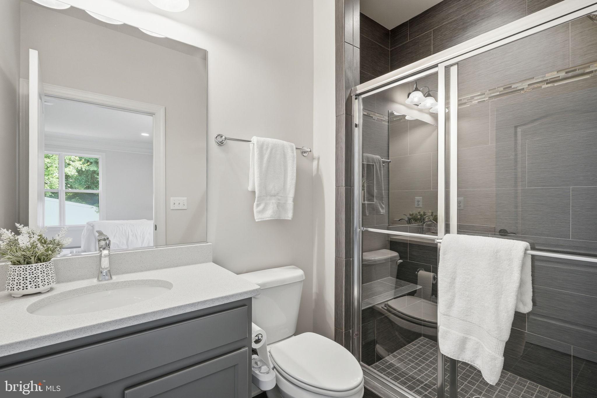 7821 Old Falls Road McLean, VA 22102 - Photo 23 of 62 a bathroom with a sink toilet mirror and shower