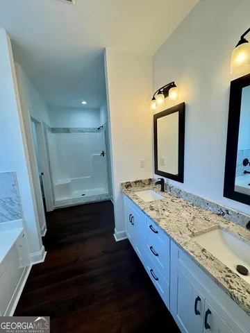 a bathroom with a granite countertop double vanity sink and a mirror