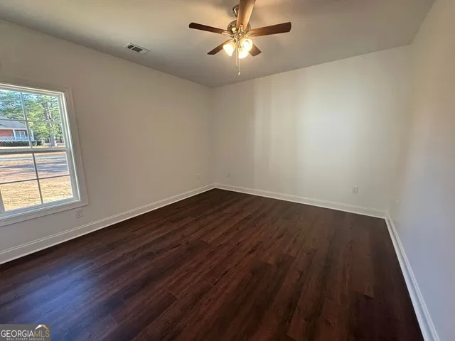 a view of a room with wooden floor and windows
